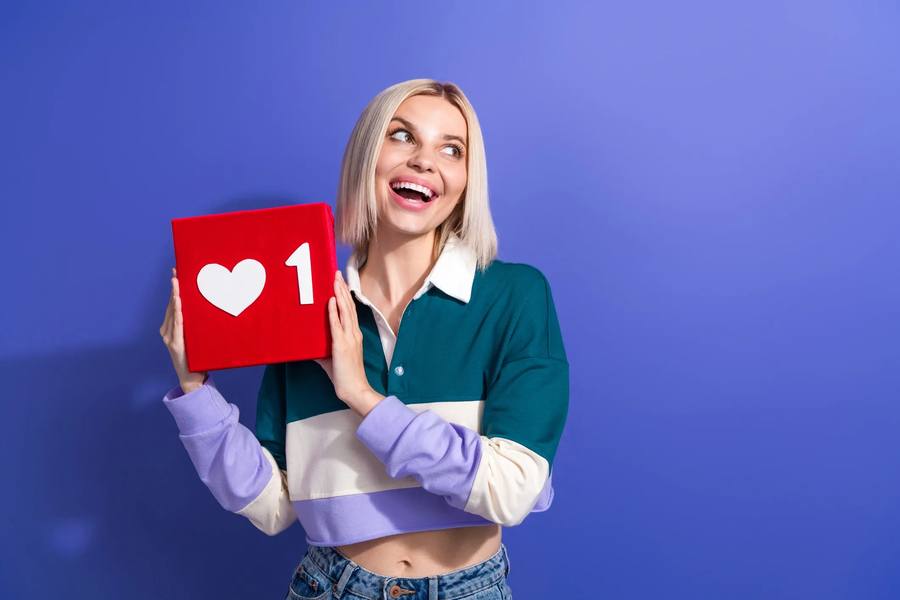 Woman holding a like icon box, representing affiliate and influencer marketing